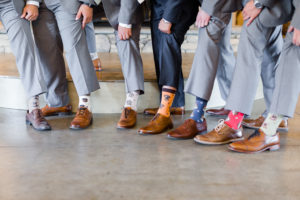 This is the groom and groomsmen showing their crazy socks with their light grey suits before the ceremony at Park Crest Events at Hoover, Alabama taken by Alabama Weddings.