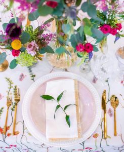 This is a set wedding tablescape with a floral linen, gold cutlery and garden variety floral in bud vases at Pursell Farms in Sylacauga, Alabama taken by Linden Photos.